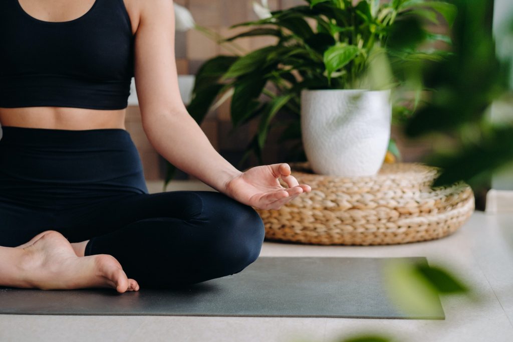 Close-up of a young woman in black clothes doing yoga in a modern gym.The concept of health